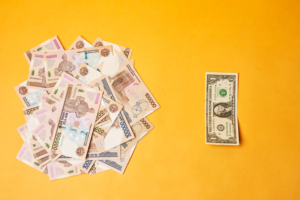 Bankbiljet en Oezbeekse sommen in Amerikaanse dollar - Foto, afbeelding
