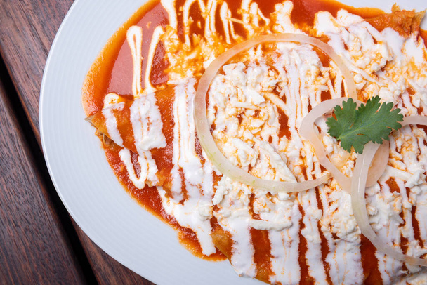 Chilaquilesia, meksikolaista ruokaa, chilikastiketta, sipsejä, nachoja. Meksikolainen perinteinen ruoka käsite puinen pöytä. - Valokuva, kuva