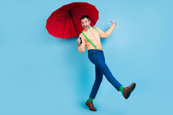 Full body photo of go brunet man with parasol wear shirt trousers socks shoes isolated on blue color background - Foto, imagen