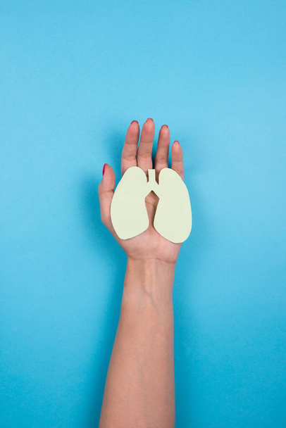 Kobiece ręce trzymają papierowy symbol płuc. - Zdjęcie, obraz