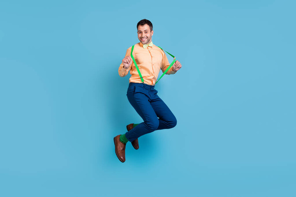 Photo of crazy funny dream guy jump have fun wear suspenders shirt bow tie isolated blue color background - Φωτογραφία, εικόνα