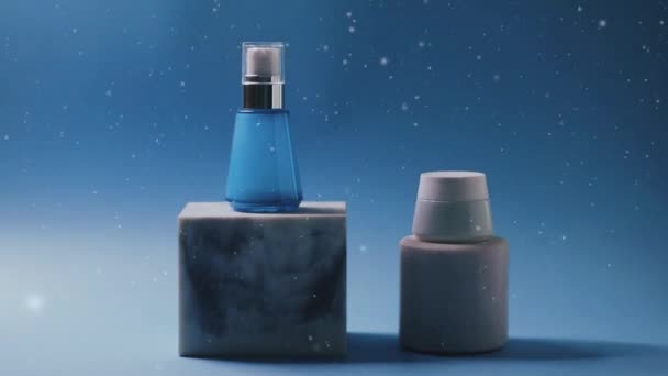 Huidverzorgingsproducten in de winter, vallende sneeuw op blauwe achtergrond, schoonheid en cosmetica - Video
