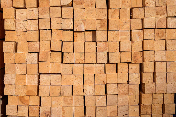 Piles of wooden planks at the sawmill for the manufacture of cladding. Warehouse of boards in the open air for the construction of houses. Timber in stacks, construction materials industry. - Foto, Imagem