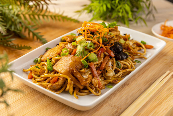 Asian style food. Noodles stir fry with ear wood mushrooms, chicken breast and vegetables - Fotó, kép