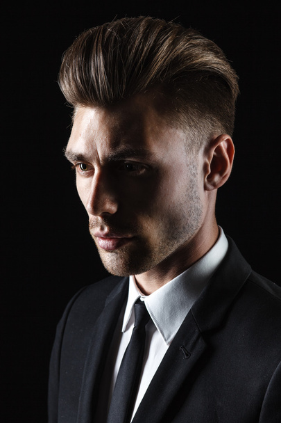 Handsome young man in suit on dark background - Fotoğraf, Görsel