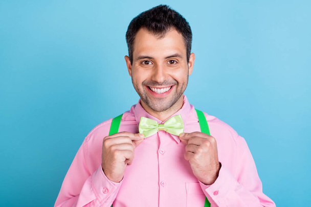 Photo of young handsome man happy positive smile correct fix bowtie date prepare isolated over blue color background - Foto, Imagem