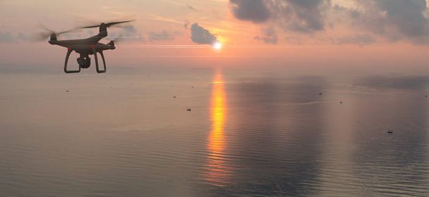 Drone quad copter con cámara digital de alta resolución en el cielo y el fondo del océano. - Foto, Imagen