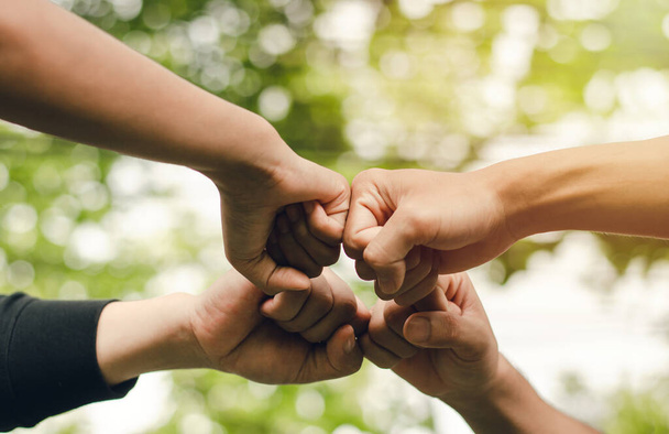 4 Personen vereinigen ihre Kräfte, das Konzept der Hand-zu-Hand, um Einheit zu schaffen, Gruppe von Menschen, Händen, Teamwork-Business-Gruppe, indem sie sich in einem Kreis Die Macht der Arbeit ist Freundschaft mit Geschäftskollegen. - Foto, Bild