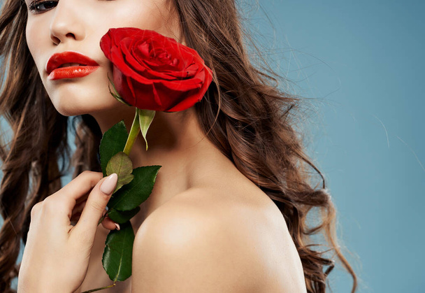 beautiful woman with rose on blue background. High quality photo - Foto, afbeelding