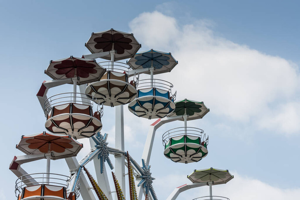 colorful carousel with view up to the clouds on the sky in a amusement park on vacation - Photo, Image