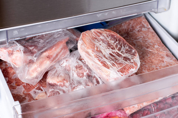 Carne crua congelada. Costeletas de porco cruas no congelador. Alimentos congelados - Foto, Imagem