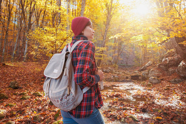 Женщина в походе смотрит на живописный пейзаж осенней листвы. - Фото, изображение