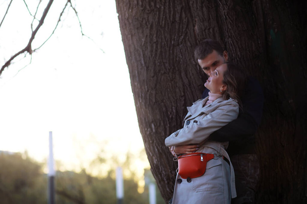 Mies ja tyttö ovat rakastuneet ensitreffeillä syksyllä kaupungin puistossa.. - Valokuva, kuva