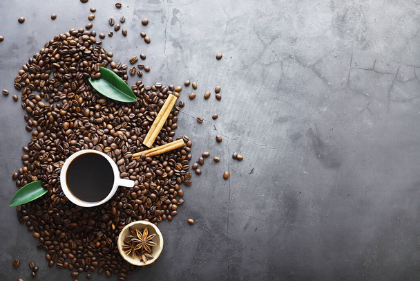 コーヒーの袋だ。テーブルの上で焙煎されたコーヒー豆。料理用の葉を持つコーヒー豆. - 写真・画像