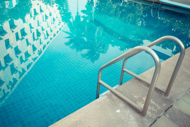 Grab bars ladder in the blue swimming pool background - Photo, Image