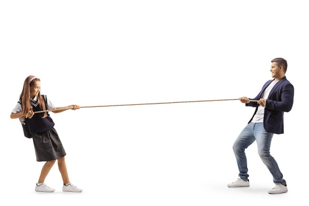 Full length profile shot of a little girl and a man pulling a rope isolated on white background - Photo, Image