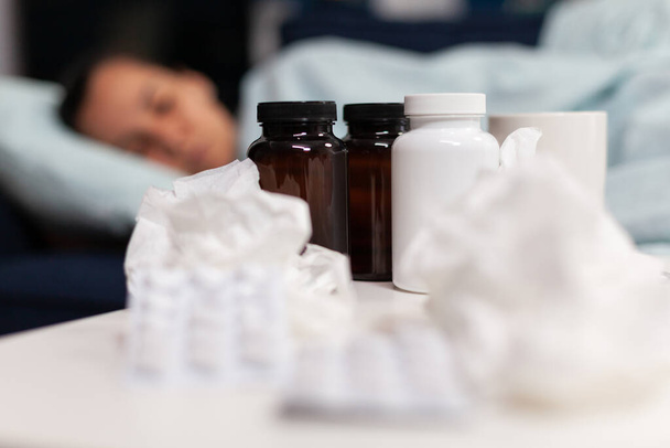 Zbliżenie leków dla chorej kobiety śpiącej na kanapie - Zdjęcie, obraz