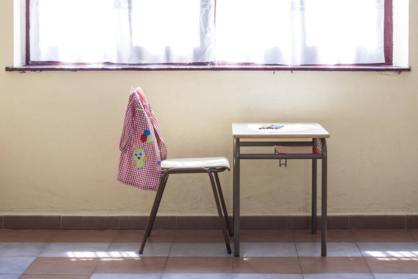 Table and chair in a school classroom.In the photo you can see the typical material of a kindergarten child.The photograph is taken in horizontal format. - Photo, Image