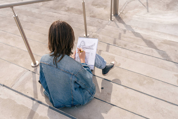 Frau sitzt auf einer Treppe mit Bleistiftzeichnung. Kunstbegriff und Inspiration - Foto, Bild