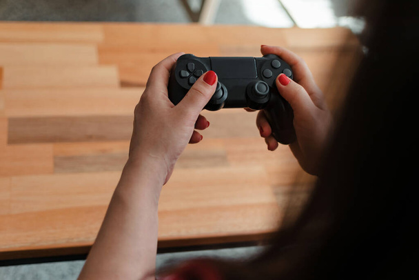 Close-up shot of the hands of a Latina woman holding a joystick - 写真・画像
