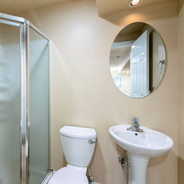 Quadratischer Rahmen Kleines Badezimmer mit Waschbecken, Toilette und halbsechseckiger Duschabtrennung mit mattierter Glasscheibe - Foto, Bild