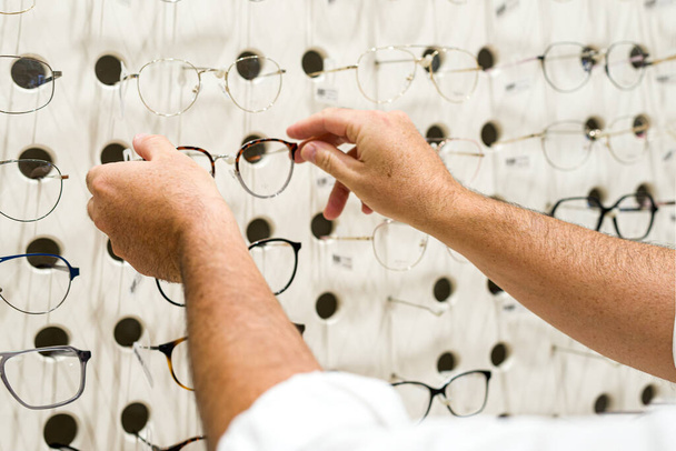 The different eyeglasses on the wall in the eyewear shop - Valokuva, kuva