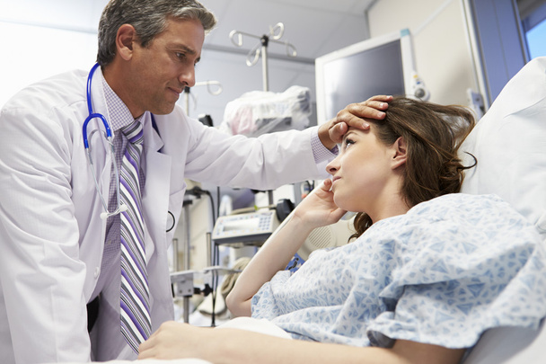 Male Doctor Examining Female Patient In Emergency Room - Фото, зображення