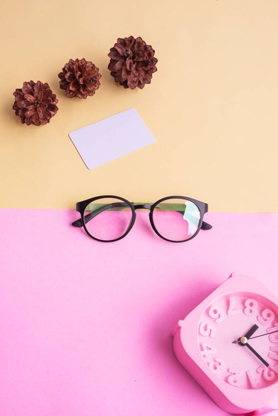 kulaté brýle na fotografii v minimálním letním stylu na pastelově růžovém a žlutém pozadí. Budík, Pine Tree Flowers, Vizitka - Fotografie, Obrázek