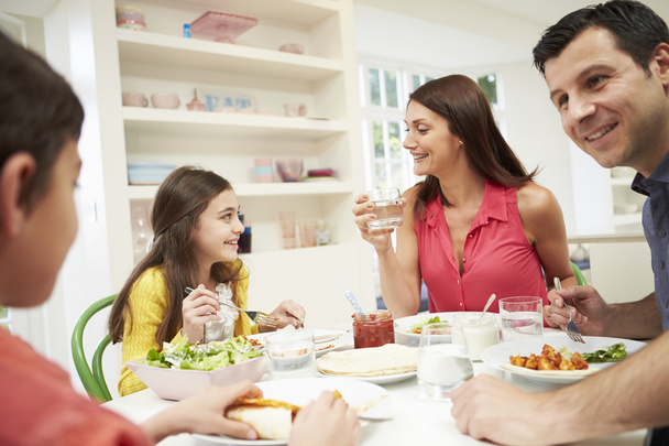 Hispanic Family Sitting At Table Eating Meal Together - Фото, изображение