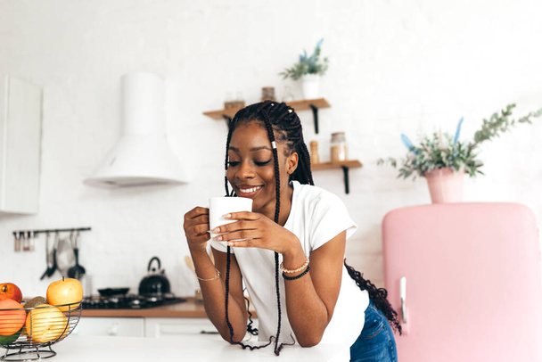 Portret młodej czarnej kobiety pijącej rano kawę lub herbatę - Zdjęcie, obraz