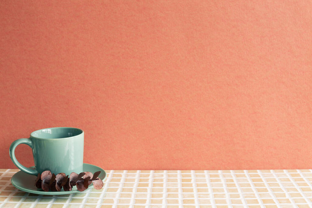 Mint coffee cup with eucalyptus leaf on mosaic tile table. red wall background - Fotoğraf, Görsel