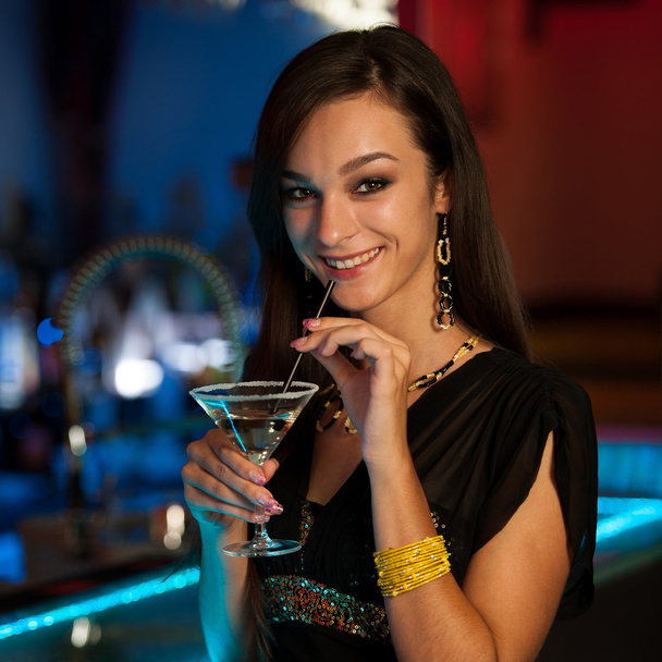Girl drinks a cocktail in night club - Фото, зображення