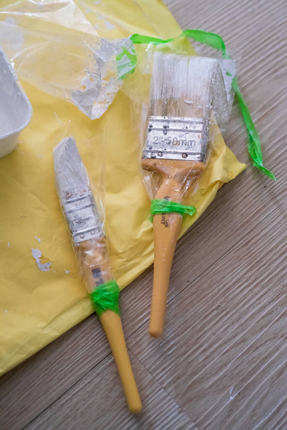 Painter's brush wrapped in plastic to prevent from drying up. Reusable for next project. - Photo, Image