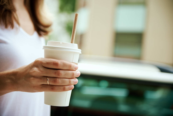 Kahve fincanı kadınların elinde. Kadın şehir caddesine gitmek için kahve içiyor.. - Fotoğraf, Görsel