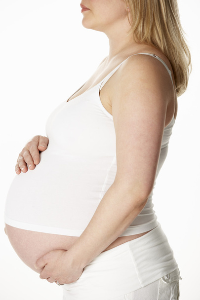 Close Up Studio Portrait Of 8 Months  Pregnant Woman Wearing Whi - Фото, изображение