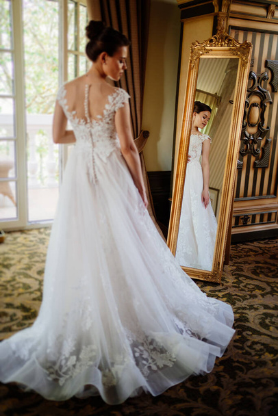 the bride at the mirror. selective focus. trying on a wedding dress  - Foto, Imagen
