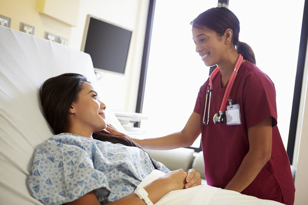 Nurse Talking To Female Patient On Ward - Valokuva, kuva