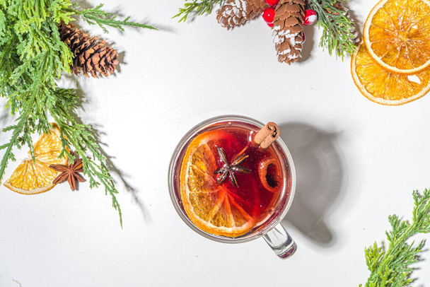Glühwein, traditionele warme winter herfst alcohol drank, met kaneel, anijs en sinaasappel, Op Kerst versierde achtergrond kopieerruimte - Foto, afbeelding