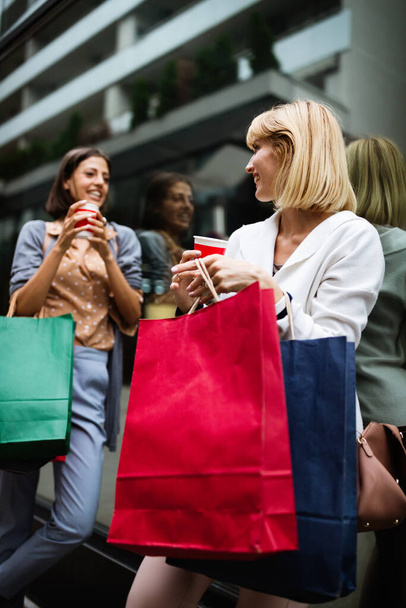 Shopping and tourism concept. Beautiful girls friends with shopping bags in ctiy - 写真・画像