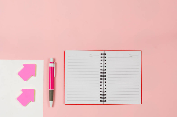 Hojas de papel, cuaderno abierto, marcadores de flecha, pluma en bac rosa - Foto, Imagen