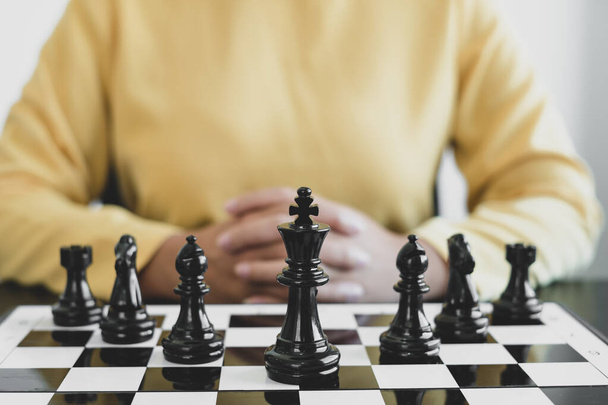 Het schaakbord toont leiderschap, de hand van de zakenvrouw in beweging, schaken in competitie toont leiderschap, volgers en zakelijke successtrategieën. - Foto, afbeelding