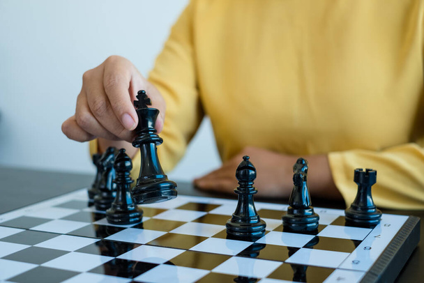 Χέρι της επιχειρηματία κινείται, σκάκι στον ανταγωνισμό δείχνει ηγεσία, οπαδούς, και στρατηγικές επιχειρηματικής επιτυχίας. - Φωτογραφία, εικόνα