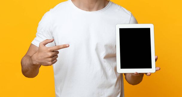 Unrecognizable guy pointing at digital tablet with blank screen - Foto, imagen
