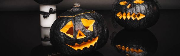 creepy dark and curved pumpkins on black, banner - Foto, afbeelding
