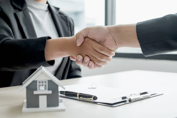 ビジネスやブローカーの不動産代理店は、住宅保険を購入し、契約に署名するための交渉を完了した後握手。住宅保険の概念. - 写真・画像