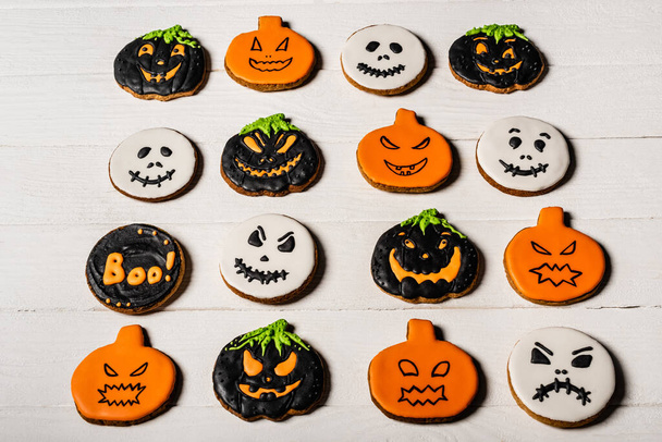 high angle view of homemade and spooky halloween cookies on white surface - Fotografie, Obrázek