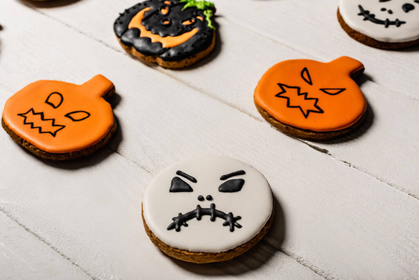 close up of sweet and spooky gingerbread cookies on white surface - Fotó, kép