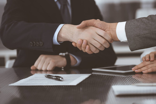 Handshake as successful negotiation ending, close-up. Unknown business people shaking hands after contract signing in modern office - Foto, immagini