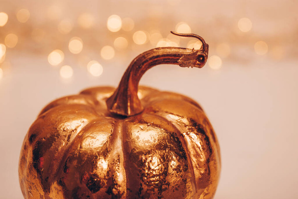 Golden autumn pumpkin on a light background with beautiful bokeh. High quality photo - Foto, Imagem
