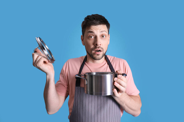 Disappointed man with pot on light blue background - Photo, image
